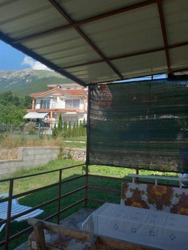a patio with a table and chairs and a house at Apartment Hristef in Ljubaništa