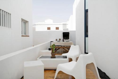 um quarto branco com cadeiras brancas e uma mesa em CASA ANCLADA en ARRIETA em Arrieta