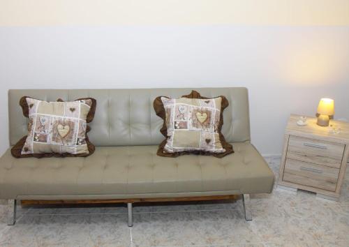 un divano con dei cuscini in un soggiorno di Largo Baluardo 13 ad Avola