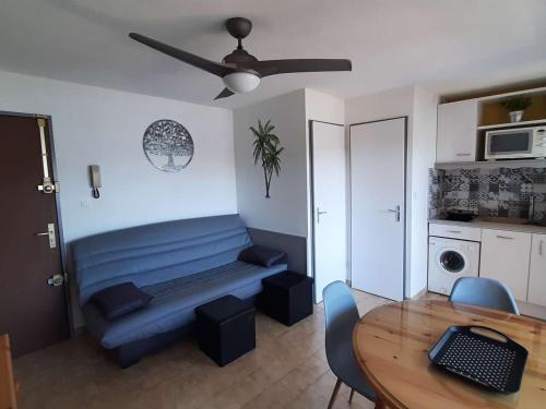 un salon avec un banc bleu et une table dans l'établissement Appartement rénové 4 pers avec loggia et parking, à 50m de la plage! - FR-1-326-757, à Marseillan