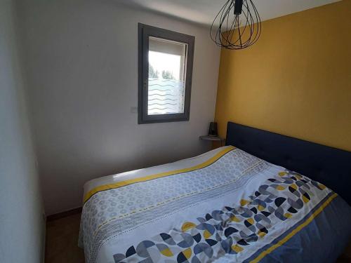 une chambre avec un lit avec une fenêtre dans l'établissement Appartement rénové 4 pers avec loggia et parking, à 50m de la plage! - FR-1-326-757, à Marseillan