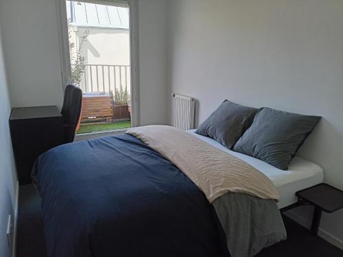 un lit avec deux oreillers dessus dans une chambre dans l'établissement Stade de France Paris, à Saint-Denis