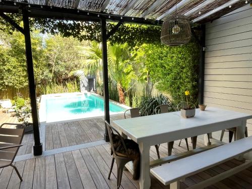 un patio avec une table et des chaises et une piscine dans l'établissement Family house Bordeaux centre, pool, garden, air conditioning, à Bordeaux