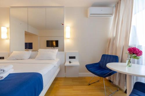 pokój hotelowy z łóżkiem, stołem i krzesłami w obiekcie Stylish Studio in New Batumi w mieście Batumi