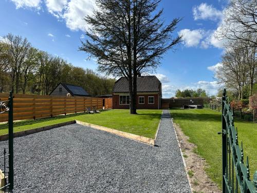 a house with a fence and a tree at ‘t Bosrandje in Odoorn