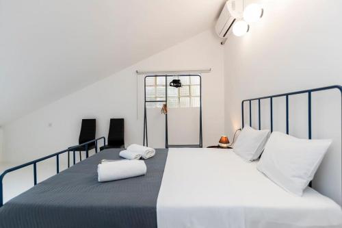 1 dormitorio blanco con 1 cama grande con almohadas blancas en 1BR Apt with Balcony In the heat of old Tbilisi, en Tiflis