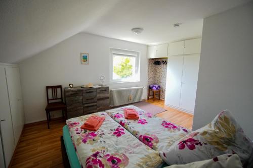 - une chambre avec un lit orné de fleurs roses dans l'établissement Stadtblick vom Herrengut, à Baden-Baden
