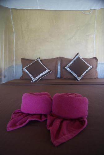 a bed with two pink towels and pillows on it at Kitelantis Hotel and Resort in Kalpitiya