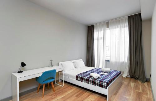 a bedroom with a bed and a desk and a chair at Stylish newly renovated 1 BR Apt on the modern Abashidze street in Tbilisi City