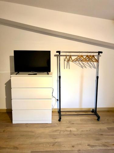 - une télévision sur une commode dans l'établissement Logement neuf et climatisé, au coeur du village, à Saint-Didier