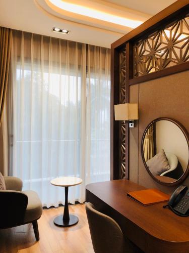 a hotel room with a desk and a mirror at Hanvet Hotel Do Son in Ðố Sơn
