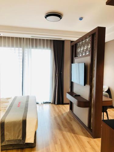 a hotel room with a bed and a television at Hanvet Hotel Do Son in Ðố Sơn