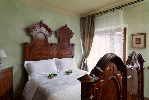 a bedroom with a large wooden bed with flowers on it at TORRE DEL GRIFONE nel medioevo di Cividale del Friuli in Faedis