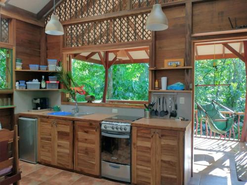 una cucina con armadi in legno e una grande finestra di Casa Mona, Jungle vibes adults only a Cocles