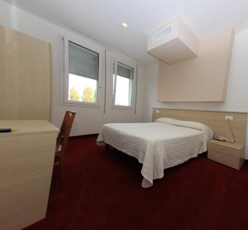 a bedroom with a bed and two windows at Park Hotel Italia in Tezze sul Brenta