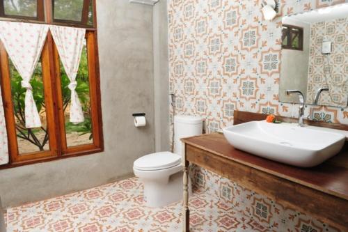 een badkamer met een witte wastafel en een toilet bij Phu-Anna Eco House in Hot