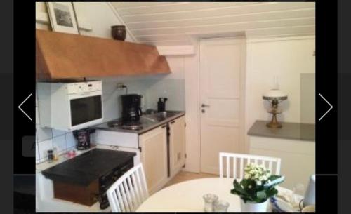 uma cozinha com uma mesa e um fogão forno superior em Lillstuga Badholmen em Fjällbacka