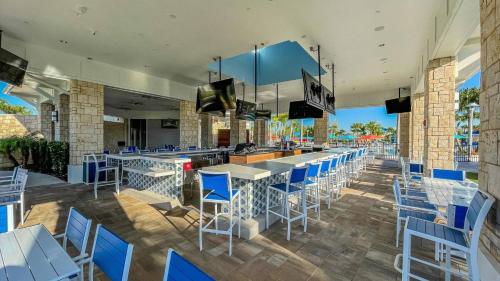 un restaurante con mesas y sillas azules y blancas en Enchanted Villa, en Orlando