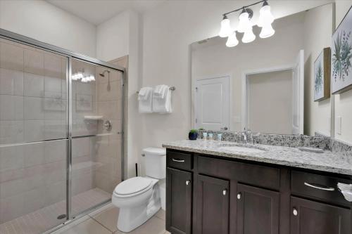 a bathroom with a toilet and a shower and a sink at Charming Retreat in Orlando
