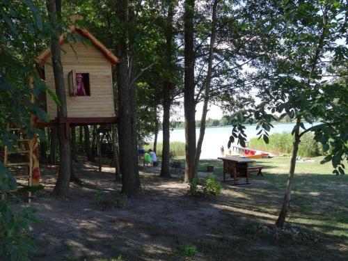 a tree house and a ping pong table in a park at Dereniowe Wzgórze in Sejny