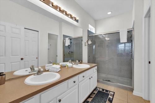 a bathroom with two sinks and a shower at Vintage Noir in Orlando