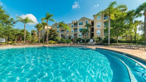 a swimming pool with palm trees and condos at Retro Noir in Orlando