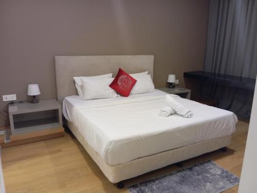 a bedroom with a white bed with two red pillows at Platinum suites klcc by Fifty One in Kuala Lumpur