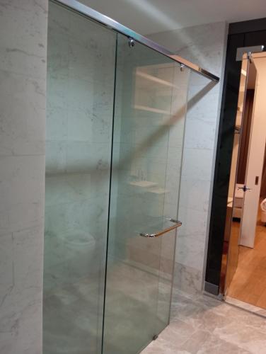 a glass shower stall with a glass door at Platinum suites klcc by Fifty One in Kuala Lumpur