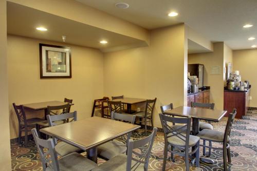 a restaurant with tables and chairs in a room at Cobblestone Inn & Suites - Hartington in Hartington