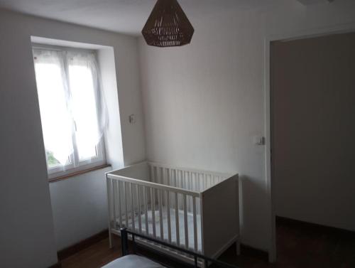 a white room with a crib and a window at Maison avec jardin in Caen