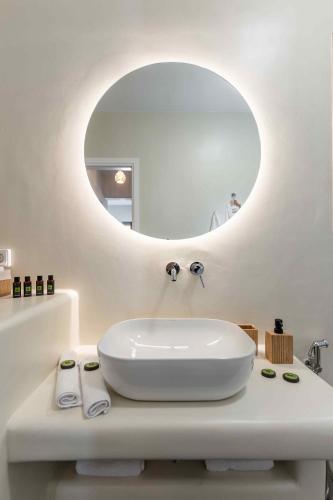 a bathroom with a white sink and a mirror at Ktima Drilli - Experience the authentic Naxian lifestyle in Áno Potamiá