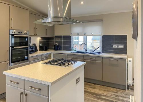a kitchen with a stove top island in a kitchen at Arran Hills in Kilwinning