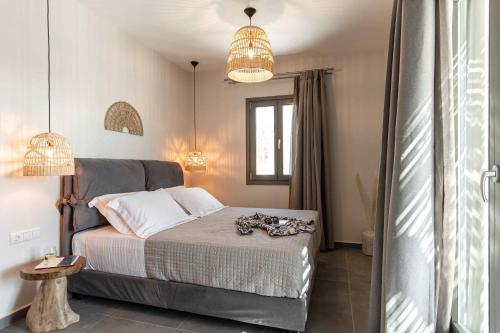 a bedroom with a bed and two pendant lights at Ktima Drilli - Experience the authentic Naxian lifestyle in Áno Potamiá
