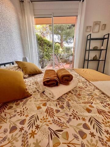 - un lit avec 2 serviettes assises au-dessus dans l'établissement Appartement avec jardin, à Cassis