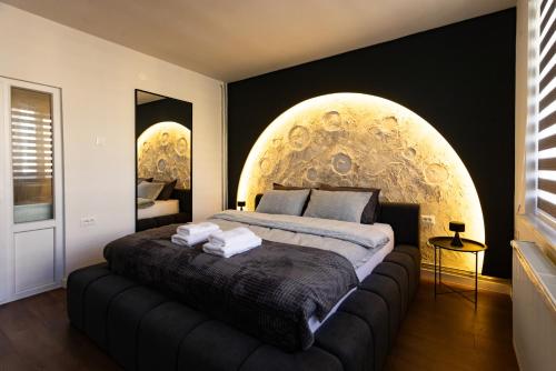 ein Schlafzimmer mit einem großen Bett mit einer Kugel an der Wand in der Unterkunft Moonlight Studio in Pristina