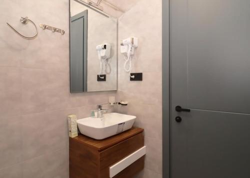 La salle de bains est pourvue d'un lavabo et d'un miroir. dans l'établissement Modern Apartment Overlooking Tbilisi, à Tbilissi