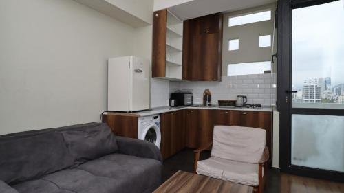 uma sala de estar com um sofá e uma cozinha em Charming 1BR Apt in Vake - By Wehost em Tbilisi
