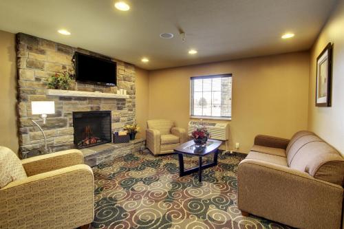 a living room with two couches and a fireplace at Cobblestone Inn & Suites - Hartington in Hartington