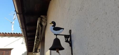 a bird on the side of a building with a bell at La Forosetta Guest House in Norcia