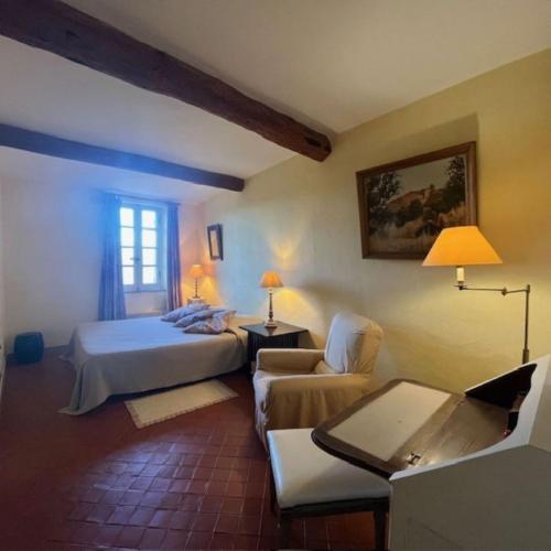 une chambre avec un lit, un canapé et une chaise dans l'établissement Maison au cœur du Village, à Gassin