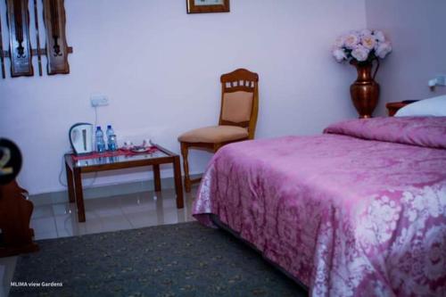 um quarto com uma cama, uma mesa e uma cadeira em MLIMAVIEW GARDENS BY Cradle Ranch em Nanyuki