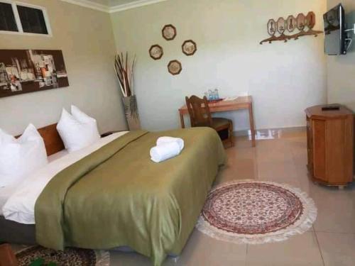 a bedroom with a bed and a desk in a room at MLIMAVIEW GARDENS BY Cradle Ranch in Nanyuki