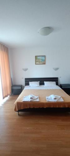 1 dormitorio con 1 cama con 2 toallas en Двустаен апартамент-Роял Палм, en Sveti Vlas