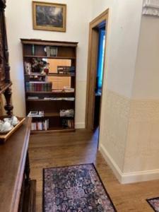 een woonkamer met een boekenplank en een tapijt bij Le Petit Chateau in Saint-Michel