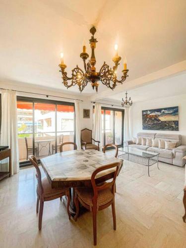d'un salon avec une table à manger et un lustre. dans l'établissement LE CANAILLOU - Hyper centre - Wifi, à Cassis