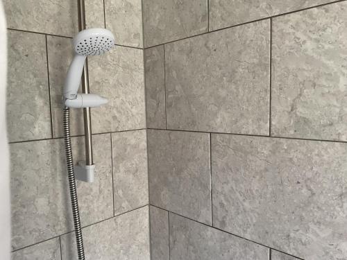 a shower head on a wall in a bathroom at Captivating 2-Bed Cottage in Grewelthorpe in Grewelthorpe