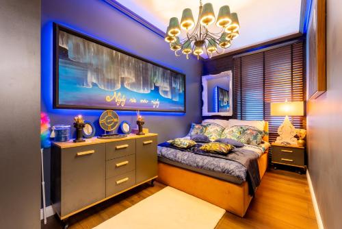 Schlafzimmer mit einem Bett und einem Kronleuchter in der Unterkunft Apartament Wonderland by Managerent in Słupsk