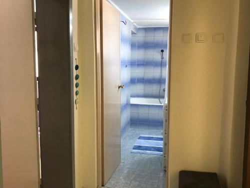 a bathroom with a door leading to a shower at Apartman Mario in Bihać