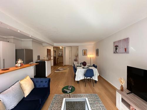 a living room with a blue couch and a table at Cosy apartment at Gates of Paris in Vincennes