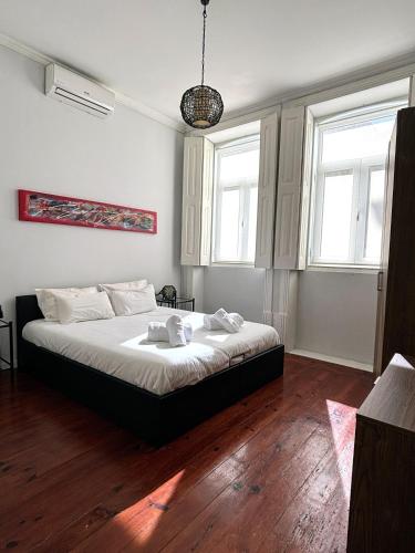 a bedroom with a bed and two windows at Covelo Apartment in Porto